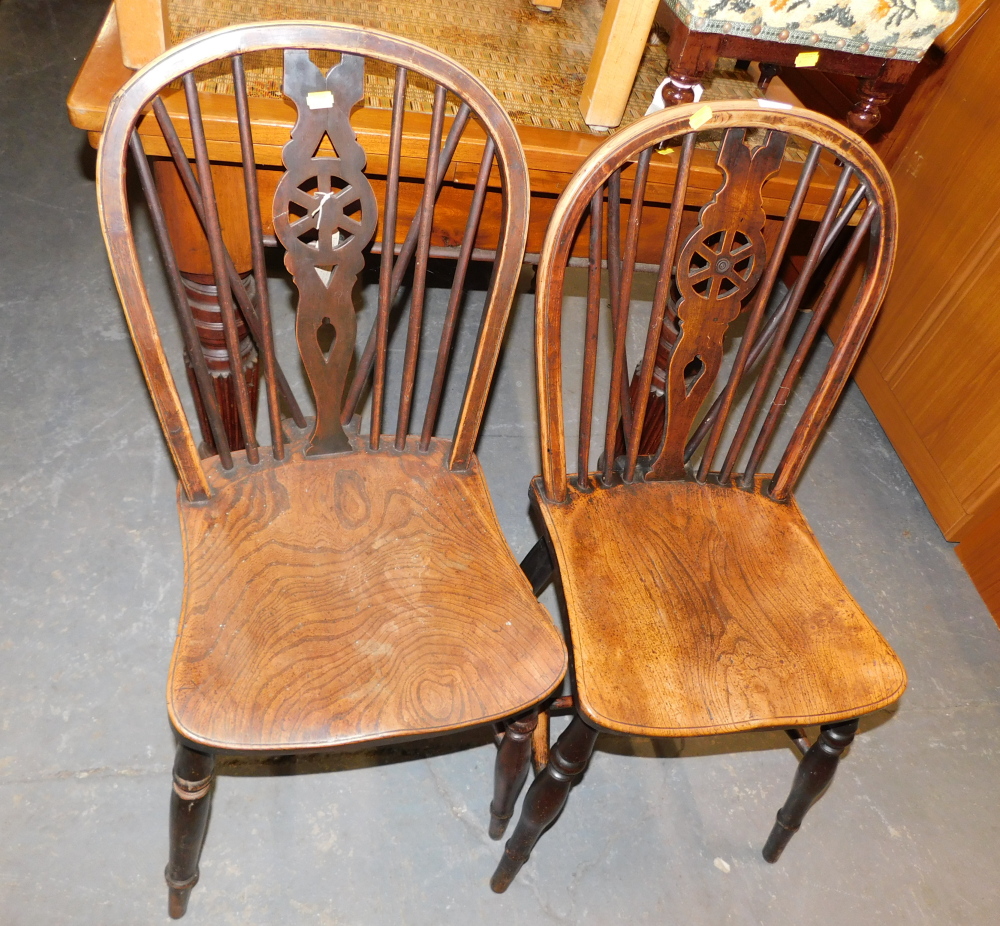 A pair of wheelback dining chairs.