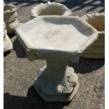 A reconstituted stone birdbath, of hexagonal form with acanthus leaf decoration, on hexagonal base,