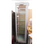 A grey painted metal glass display case, on tapered legs.