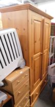 A pine double wardrobe, with two cupboard doors and single drawer.