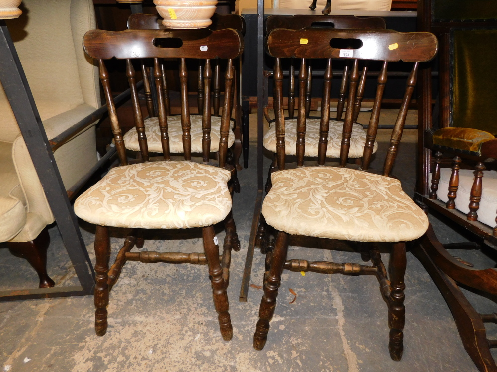 A set of four stained beech pub chairs, each with gold leaf pattern upholstery. The upholstery in t