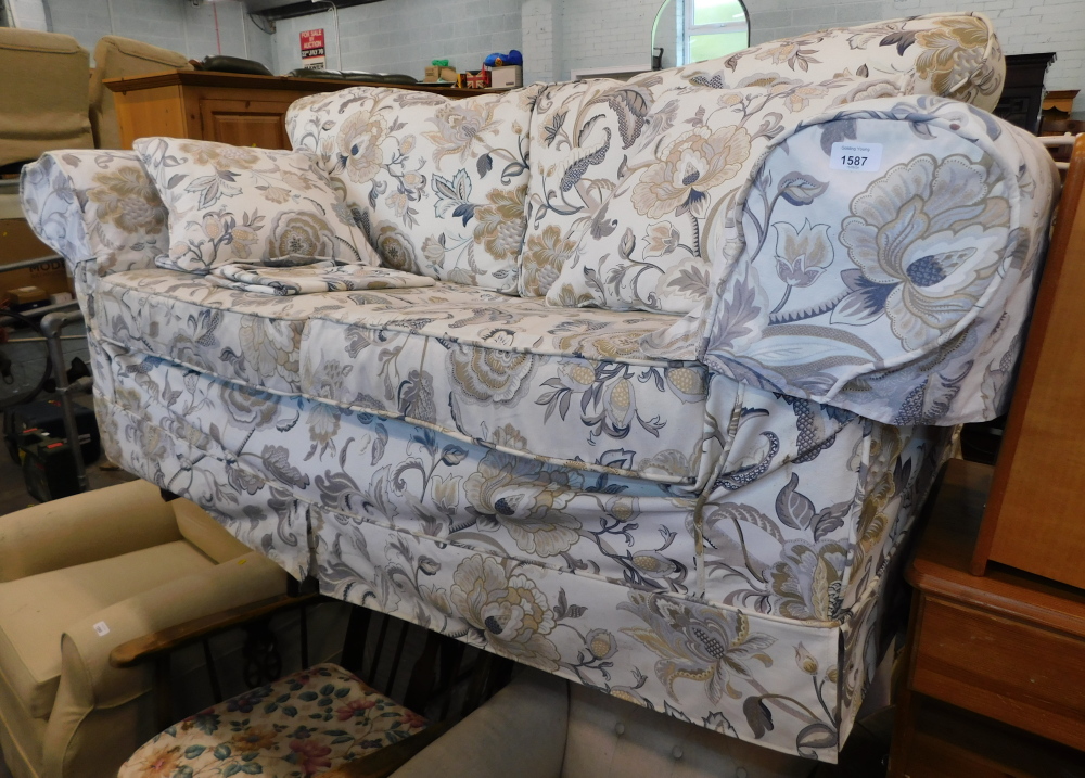 A material two seat sofa, with oval cushions in the William Morris style.