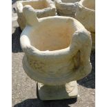 A reconstituted stone two handled urn planter, in the Neoclassical style, on a circular foot, 50cm h