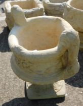 A reconstituted stone two handled urn planter, in the Neoclassical style, on a circular foot, 50cm h