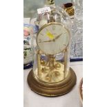 A brass anniversary clock, with glass dome.