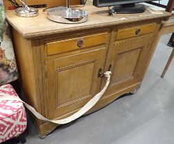 A pine sideboard, with plain plank top above arrangement of two drawers and two cupboard doors, with