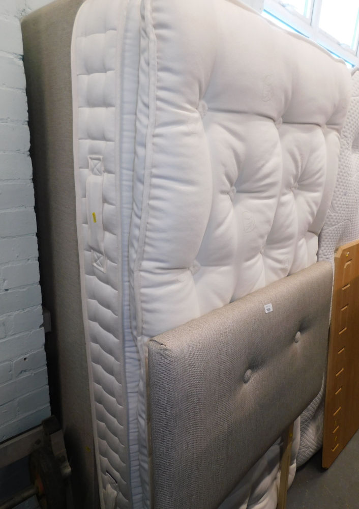 A grey single divan bed, with headboard, base and mattress.