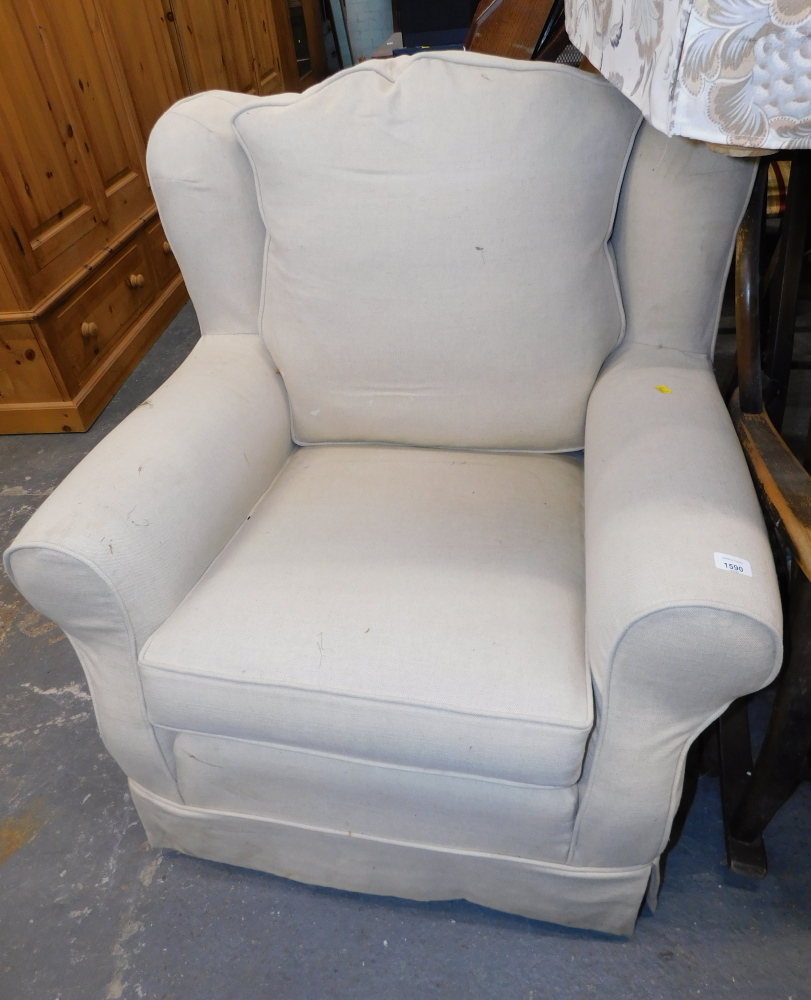 A cream upholstered armchair.