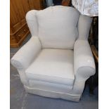 A cream upholstered armchair.