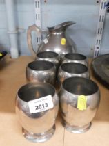 A Manor period pewter jug, together with six beakers, numbered 2667, stamped to underside.