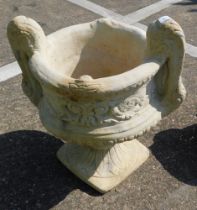 A reconstituted stone two handled urn planter, in the Neoclassical style, on a circular foot, 50cm h