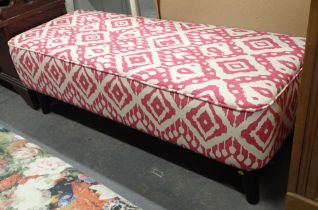 A modern finish long stool, decorated on pink and cream ground, with ebonised legs.