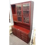 A mahogany wall unit, with cupboard and glazed top above arrangement of two cupboards and three draw