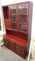 A mahogany wall unit, with cupboard and glazed top above arrangement of two cupboards and three draw