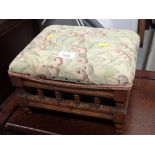 A Victorian foot stool, with berry tapestry seat, on oak column base.