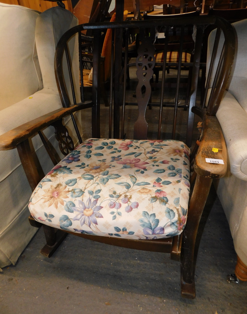 A wheelback oak rocking chair, with padded seat. The upholstery in this lot does not comply with th