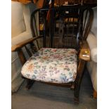 A wheelback oak rocking chair, with padded seat. The upholstery in this lot does not comply with th