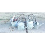 Three galvanized metal watering cans, together with bucket, garden tools, four wrought metal plant s
