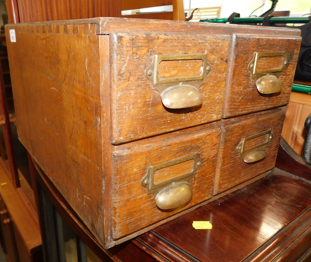 A 20thC oak four drawer index card chest.