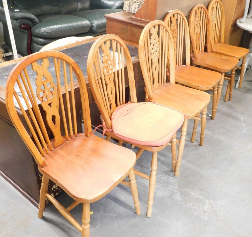 A set of six pine wheel back chairs.