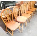 A set of six pine wheel back chairs.