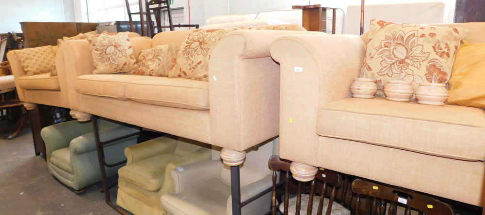 A terracotta sofa suite, comprising three seater sofa, two seater sofa, and an armchair with scatter