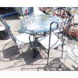 A circular glass top dining table, on a wrought iron base, together with four matching chairs.