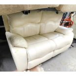 A cream leatherette two seater reclining sofa.