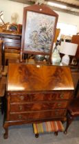 An oak bureau, fall flap with leather inset, above arrangement of three drawers, on ball and claw fe