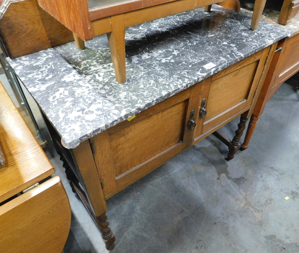 A 20thC wash stand, with a moulded oak top, on marble top, with two cupboard drawers, on tapered leg