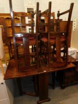 An oak drop leaf dining table and set of four chairs with upholstered seats.