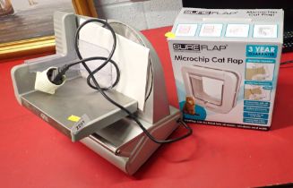 An electric meat slicer, together with a Sure Flap battery operated cat flap.