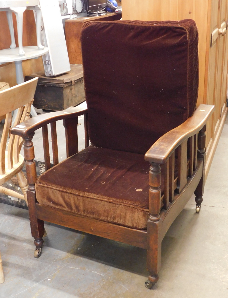 An oak steamer chair, with two brown cushions. The upholstery in this lot does not comply with the