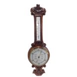 An early 20thC carved oak aneroid barometer, with thermometer, 79cm high.