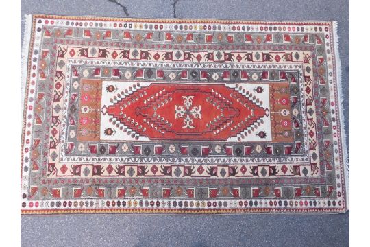 A rug, with central medallion within multiple borders, in khaki green, cream, pale yellow and red, - Image 2 of 4