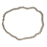 A single strand cultured pearl necklace, on knotted string stand, with yellow metal clasp stamped 14