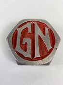 Vintage Car Motor Vehicle threaded alloy hub cap with the letters G N on a red background,
