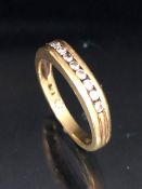 18ct Gold contemporary style ring set with band of 9 diamonds flanked with fluted shoulders size