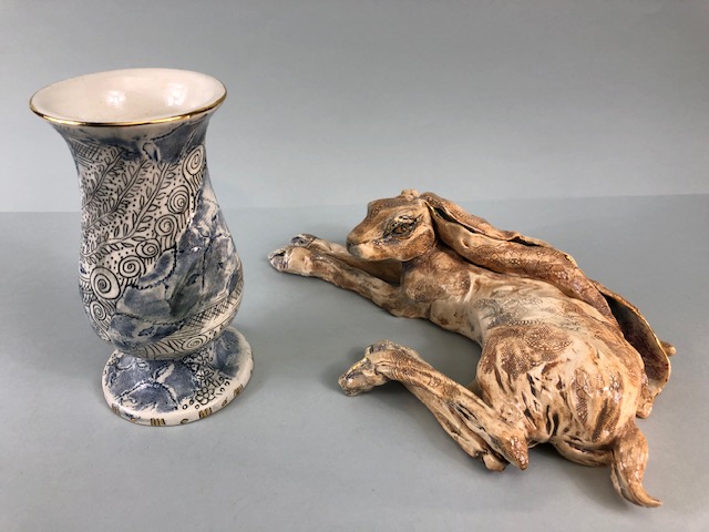 Art pottery , pleasing study of a recumbent hare with incised decoration ang gilt highlights,