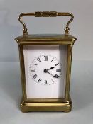 Antique style brass four glass panel chiming carriage clock, white face with roman numerals,