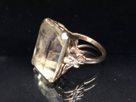 9ct yellow gold ring mounted with a pale quartz Emerald cut stone the shoulders of butterfly