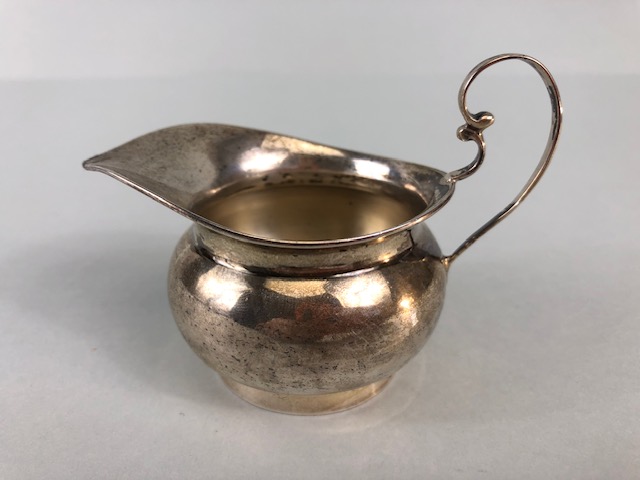 Silver hallmarked creamer on pedestal base with rounded body and scroll handle maker T.W approx 48g