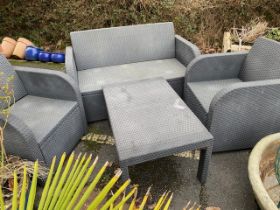 Modern garden patio suite consisting of two seater sofa, two armchairs, table and cushions