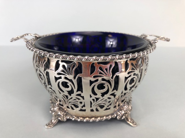 Silver hallmarked open work or pierced design basket with twin handles on four splayed feet