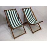 Pair of vintage wooden framed deckchairs with green and white striped fabric