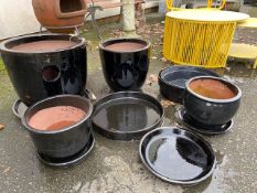 Collection of glazed black garden pots and pot bases