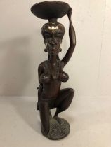 African Sculpture, a large carved wooden statue of a Kneeling woman wearing beads and carrying a