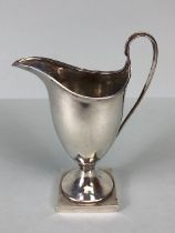 Silver Hallmarked jug on square base looping handle and fluted spout and rim, hallmarked for Chester