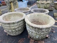 Four circular similar concrete garden planters