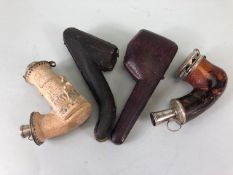 Meerschaum pipes Four carved pipes all with silver metal mounts 2 with amber stems and cases